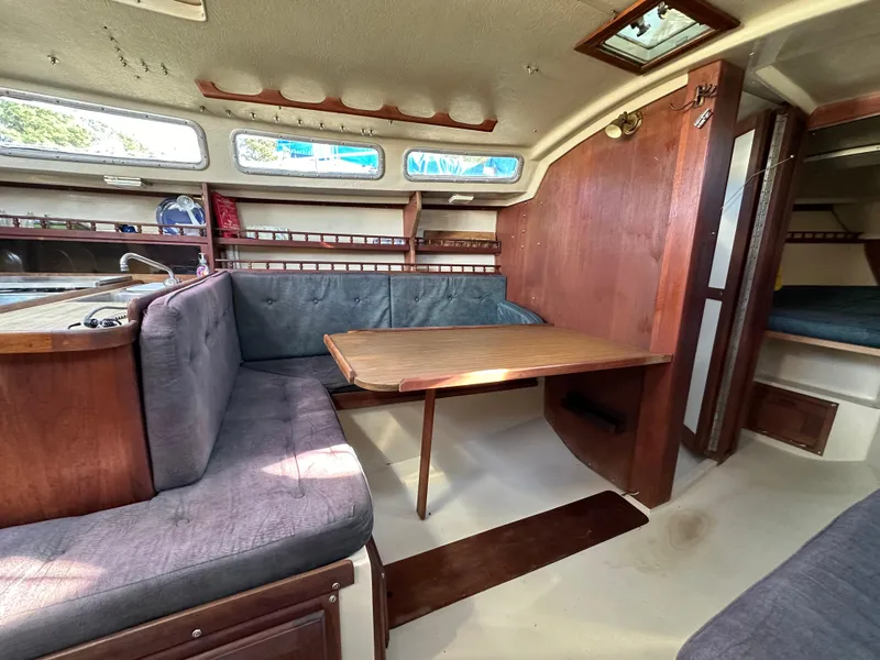 Slide: The Image of Interior of 1983 Catalina 30 Tall Rig sailboat with dining area and wooden table. - 43