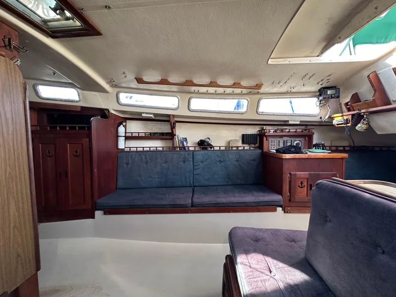 Slide: The Image of Interior of 1983 Catalina 30 Tall Rig sailboat with blue seating and wooden cabinetry. - 45