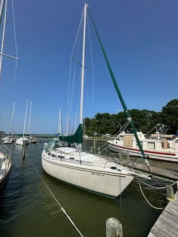 Slide: The Image of 1983 Catalina 30 Tall Rig sailboat docked at a marina under clear blue skies. - 8