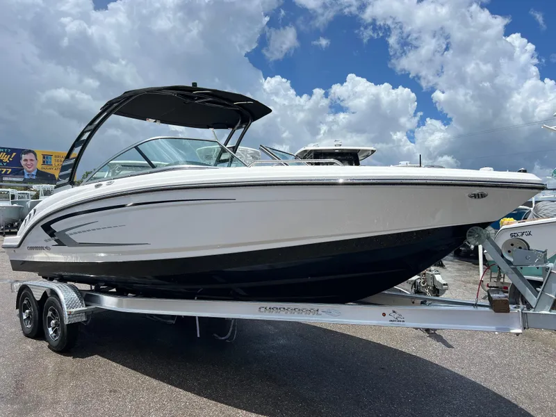 Slide: The Image of 2024 Chaparral 23 SSi OB boat on a trailer under a cloudy sky. - 0