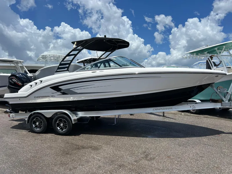 Slide: The Image of 2024 Chaparral 23 SSi OB boat on a trailer under a blue sky with clouds. - 1