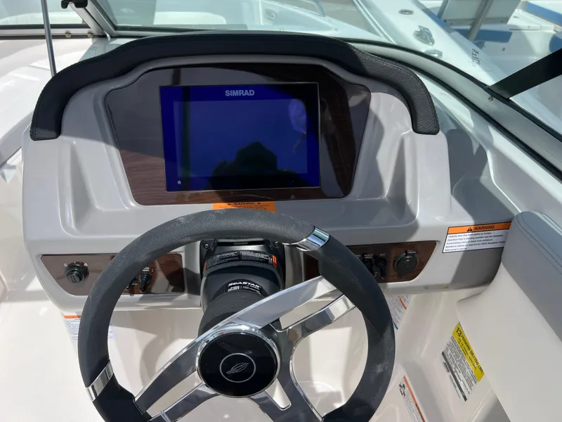 Slide: The Image of 2024 Chaparral 23 SSi OB boat dashboard with Simrad display and steering wheel. - 11
