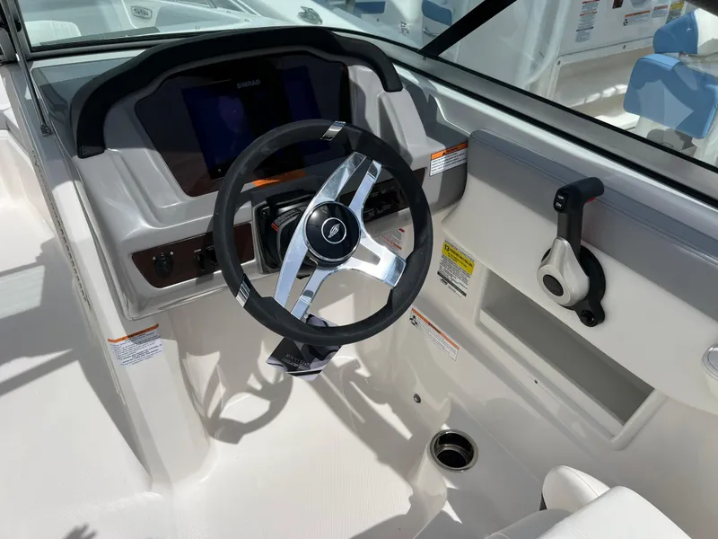 Slide: The Image of 2024 Chaparral 23 SSi OB boat cockpit with steering wheel and control panel. - 12