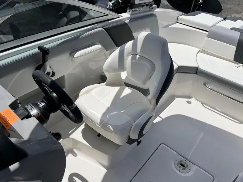 Slide: The Image of 2024 Chaparral 23 SSi OB boat interior with white captain's chair and steering wheel. - 17