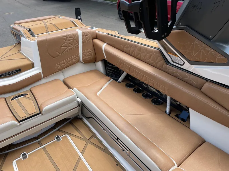 Slide: The Image of 2024 Nautique Super Air Nautique G25 Paragon interior with tan leather seating and cup holders. - 11
