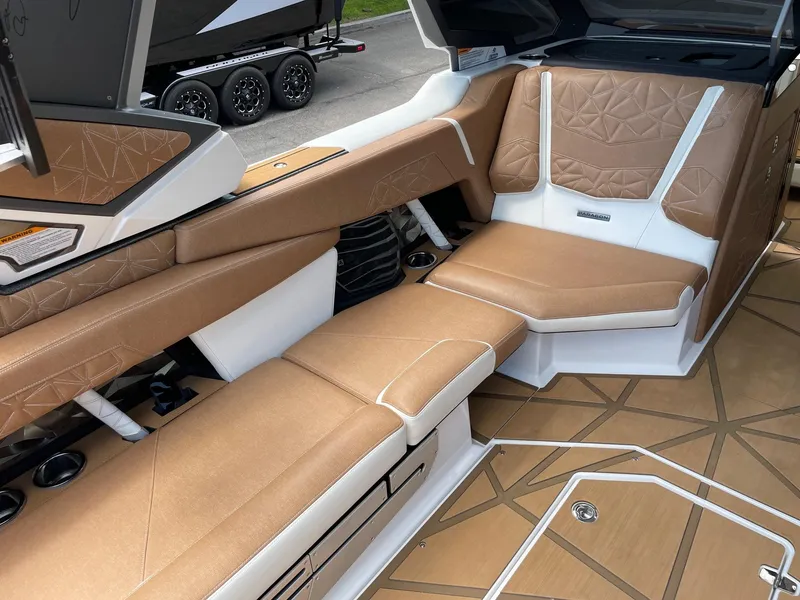 Slide: The Image of 2024 Nautique Super Air Nautique G25 Paragon interior with tan and white seating. - 12