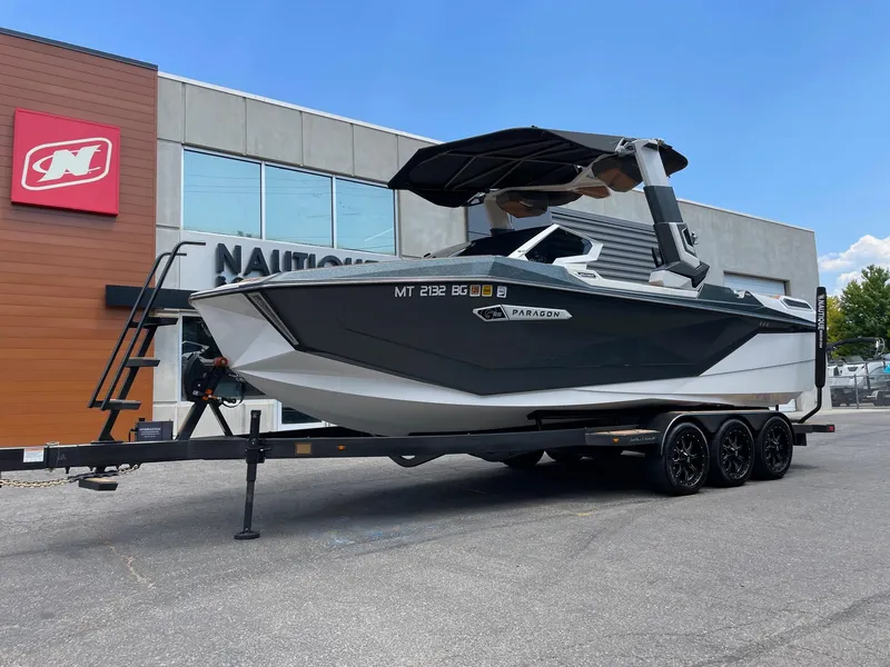 Slide: The Image of 2024 Nautique Super Air Nautique G25 Paragon boat on a trailer outside dealership. - 2