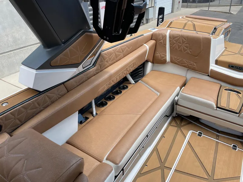 Slide: The Image of 2024 Nautique Super Air Nautique G25 Paragon interior with tan leather seating and cup holders. - 9