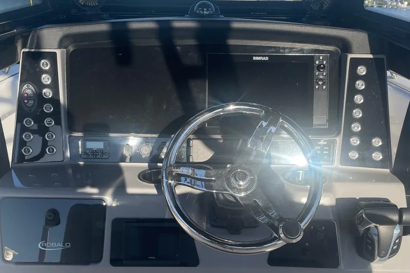 Slide: The Image of 2022 Robalo R272 Center Console helm with steering wheel and electronic displays. - 10
