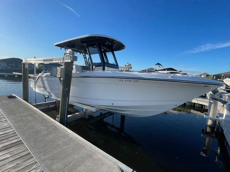 Slide: The Image of 2022 Robalo R272 Center Console boat docked at marina. - 2
