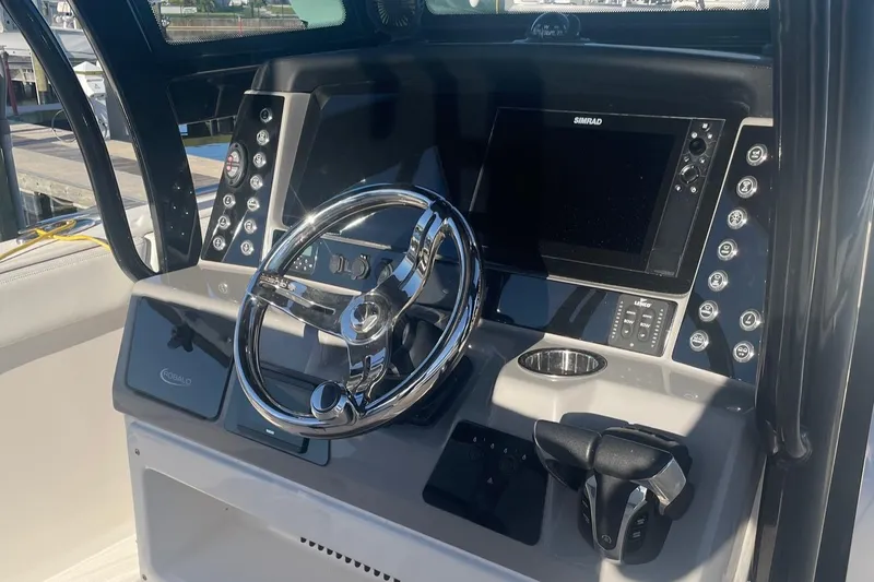Slide: The Image of 2022 Robalo R272 Center Console boat dashboard with steering wheel and navigation system. - 8