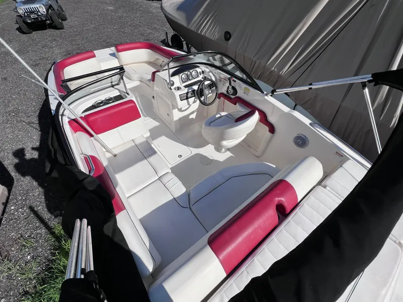 Slide: The Image of 2016 Bayliner 195 Deck Boat with white and red interior, parked on gravel. - 10