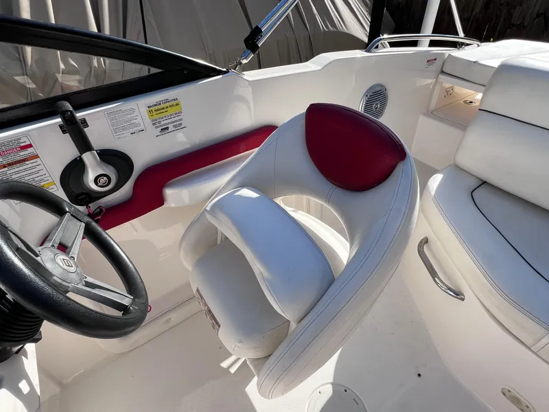 Slide: The Image of 2016 Bayliner 195 Deck Boat cockpit with steering wheel and white seating. - 16
