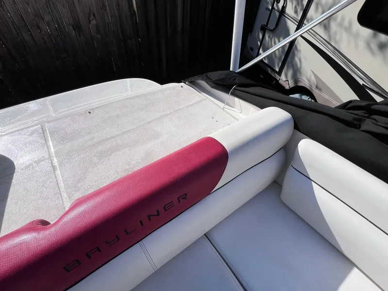 Slide: The Image of 2016 Bayliner 195 Deck Boat interior with white and red seating. - 26