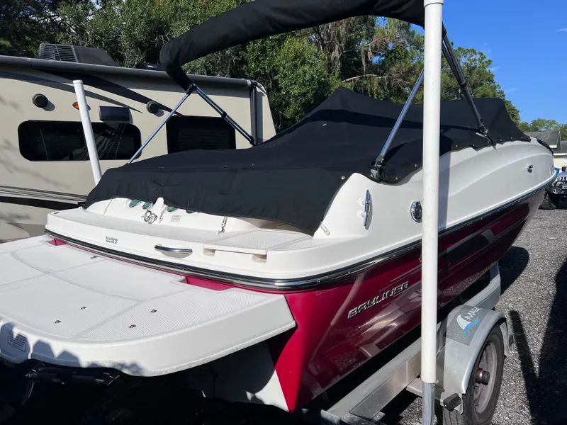 Slide: The Image of 2016 Bayliner 195 Deck Boat on trailer, covered and parked outdoors. - 3