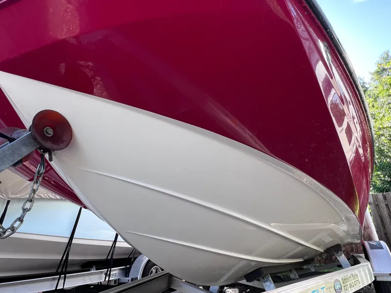 Slide: The Image of 2016 Bayliner 195 Deck Boat on trailer, red and white hull close-up. - 6
