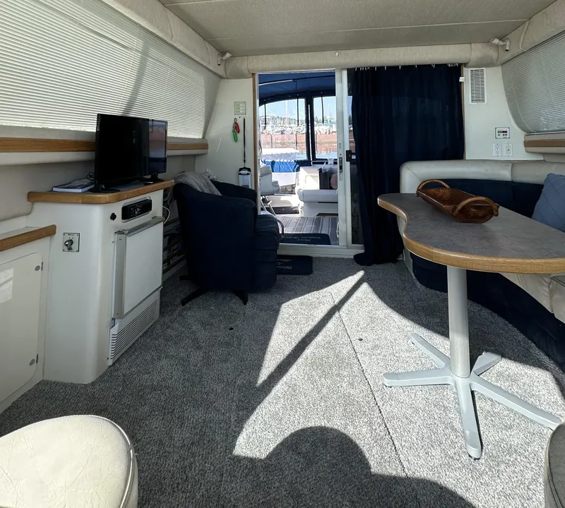 Slide: The Image of Interior of 1996 Sea Ray 370 Sedan Bridge yacht with seating, table, and TV. - 11