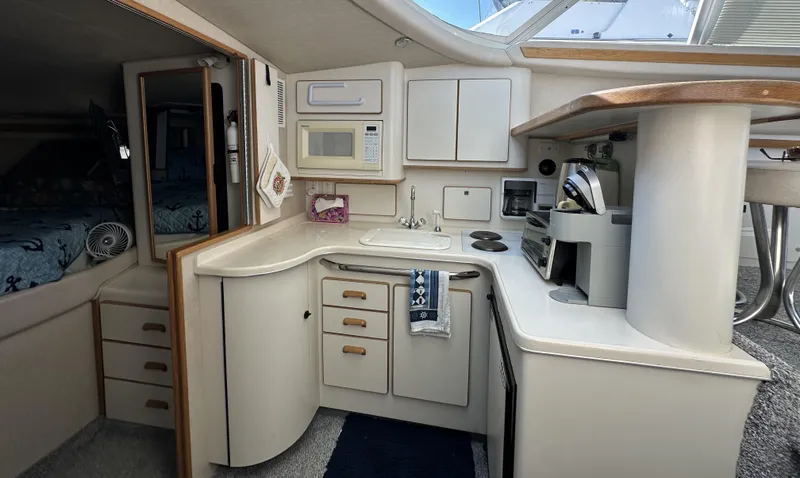Slide: The Image of 1996 Sea Ray 370 Sedan Bridge kitchen with modern appliances and ample storage. - 13