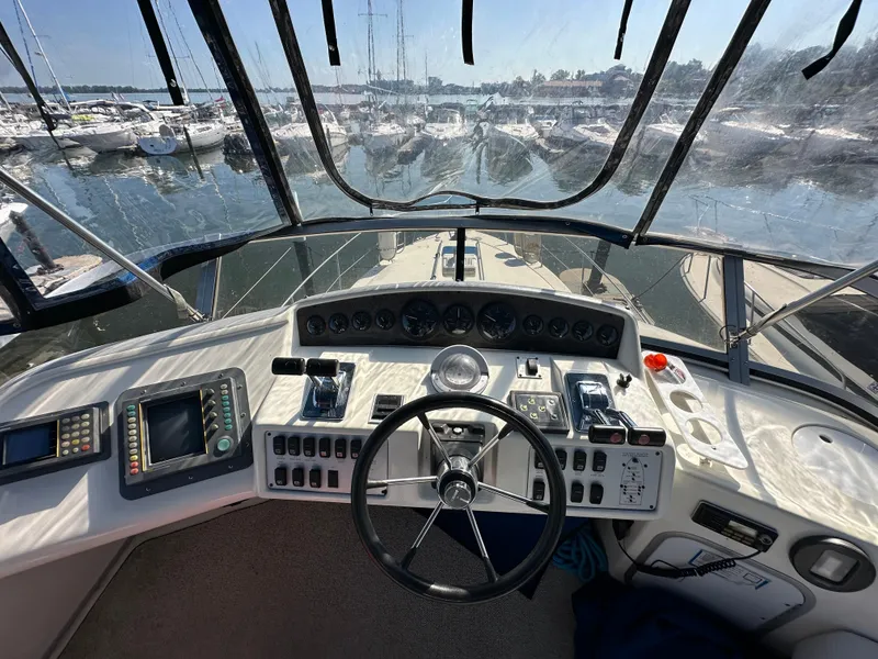 Slide: The Image of 1996 Sea Ray 370 Sedan Bridge helm with navigation equipment and marina view. - 17