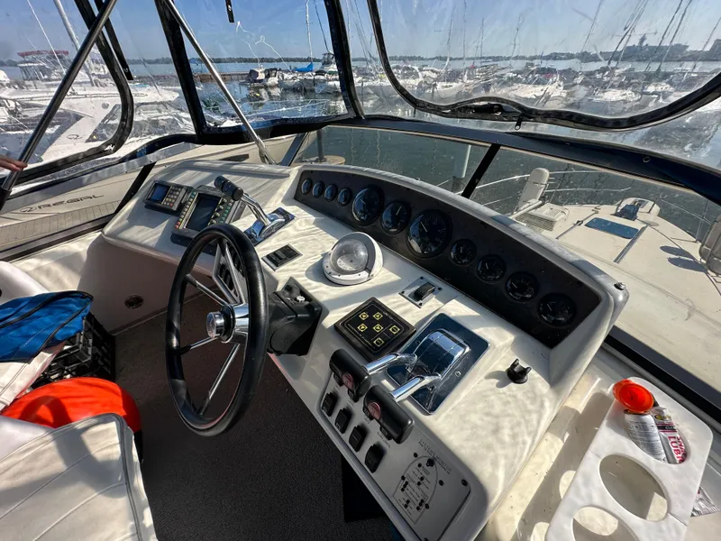 Slide: The Image of 1996 Sea Ray 370 Sedan Bridge helm with navigational instruments and marina view. - 18