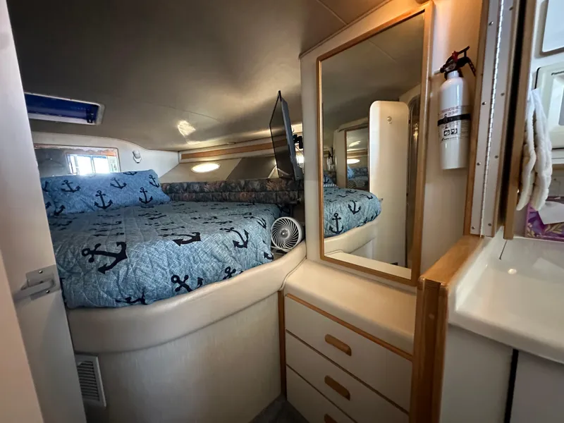 Slide: The Image of 1996 Sea Ray 370 Sedan Bridge cabin with bed, mirror, and storage drawers. - 29