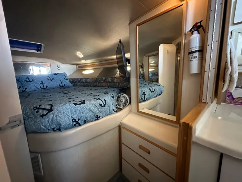 Slide: The Image of Cozy bedroom in 1996 Sea Ray 370 Sedan Bridge yacht with anchor-themed bedding. - 30