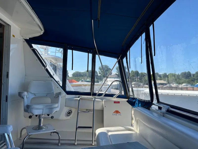 Slide: The Image of 1996 Sea Ray 370 Sedan Bridge interior with blue canopy and white seating. - 38
