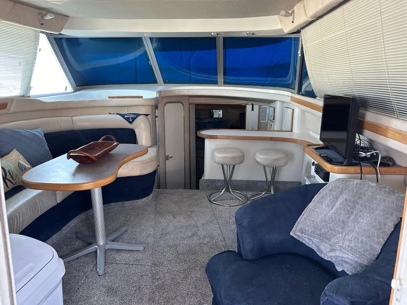 Slide: The Image of Interior of 1996 Sea Ray 370 Sedan Bridge with seating, table, and TV. - 7