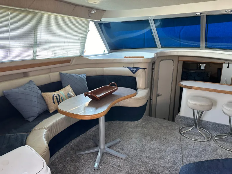 Slide: The Image of Interior of 1996 Sea Ray 370 Sedan Bridge with cozy seating and dining area. - 9