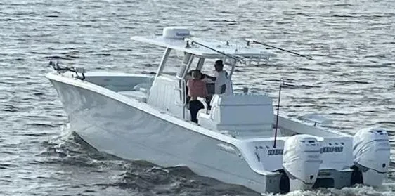 Slide: The Image of 2022 Invincible 33 Catamaran cruising on the water with two people onboard. - 10