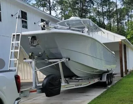 Slide: The Image of 2022 Invincible 33 Catamaran on trailer parked beside a white house. - 5