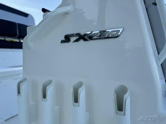 Slide: The Image of 2024 Skeeter SX230 boat detail with rod holders and model emblem. - 10