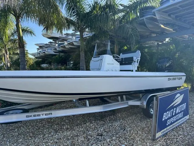 Slide: The Image of 2024 Skeeter SX230 boat on trailer at Boat & Motor Superstores, surrounded by palm trees. - 2