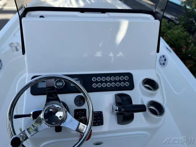Slide: The Image of 2024 Skeeter SX230 boat console with steering wheel and control panel. - 24
