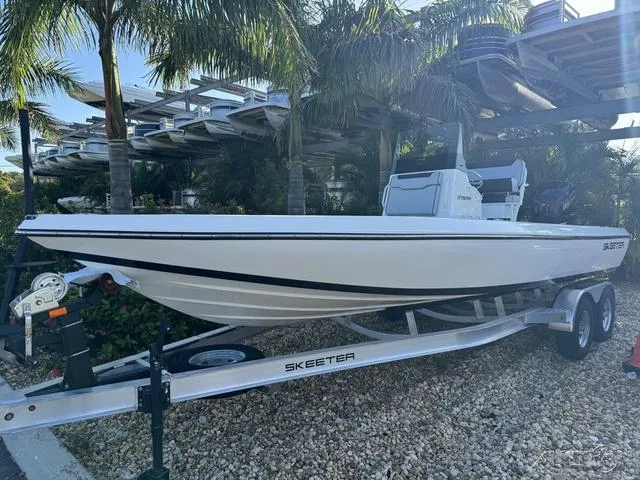 Slide: The Image of 2024 Skeeter SX230 boat on trailer, parked outdoors near palm trees. - 3
