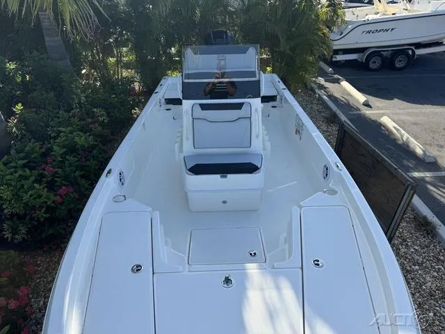 Slide: The Image of 2024 Skeeter SX230 boat with white deck and seating, parked outdoors. - 30