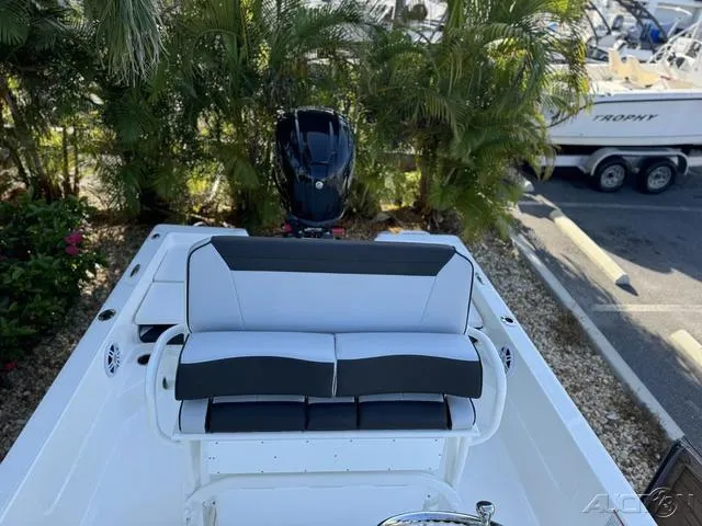 Slide: The Image of 2024 Skeeter SX230 boat with cushioned seating and outboard motor. - 35