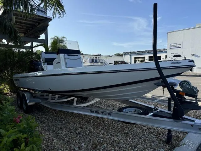Slide: The Image of 2024 Skeeter SX230 boat on a trailer in a marina. - 7