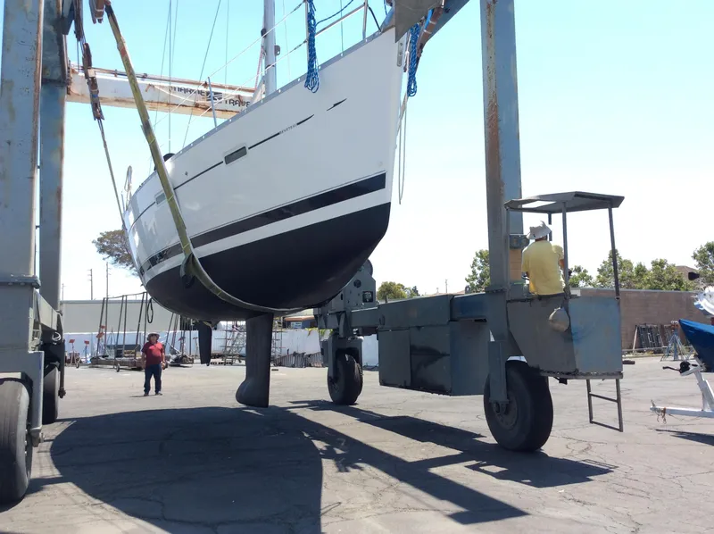 Slide: The Image of 2005 Beneteau 373 sailboat being lifted by a boat hoist in a marina. - 34
