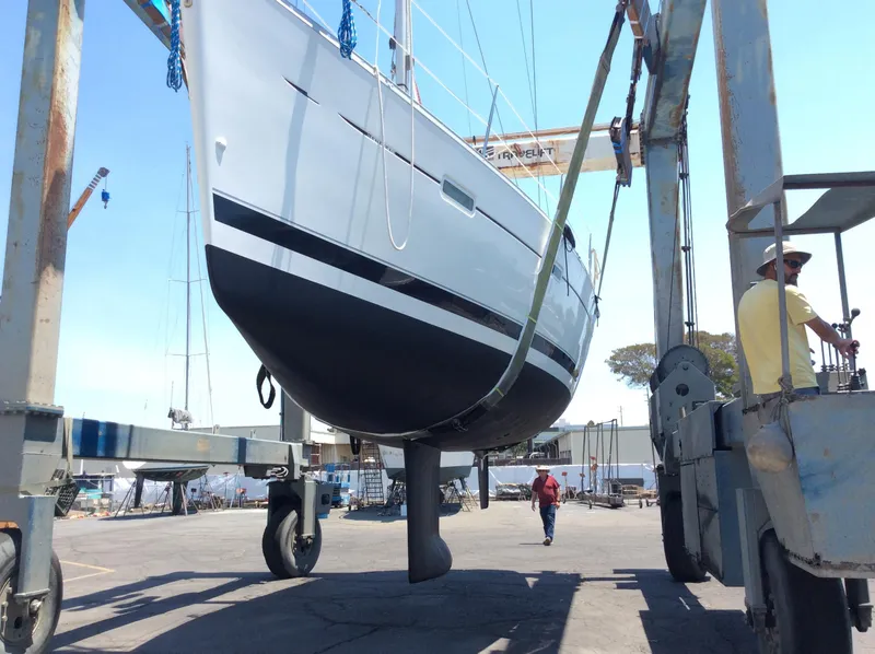 Slide: The Image of Beneteau 373 sailboat from 2005 being lifted by a boat hoist in a shipyard. - 35
