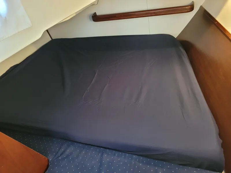 Slide: The Image of Interior cabin bed of 2005 Beneteau 373 sailboat with dark bedding. - 38