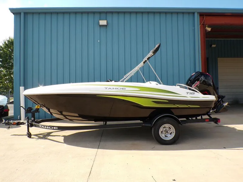 The Image of 2024 Tahoe T18 boat on trailer, parked outside a blue building. - 1