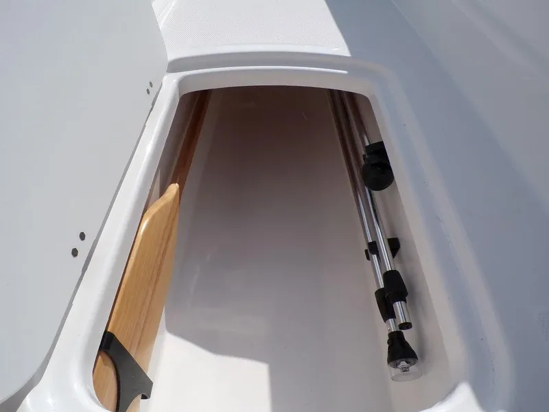 Slide: The Image of 2024 Tahoe T18 storage compartment with wooden panel and metal poles. - 12