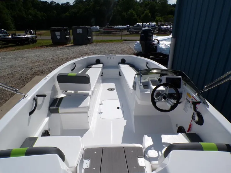 Slide: The Image of 2024 Tahoe T18 boat interior with seating and steering wheel, parked outdoors. - 16