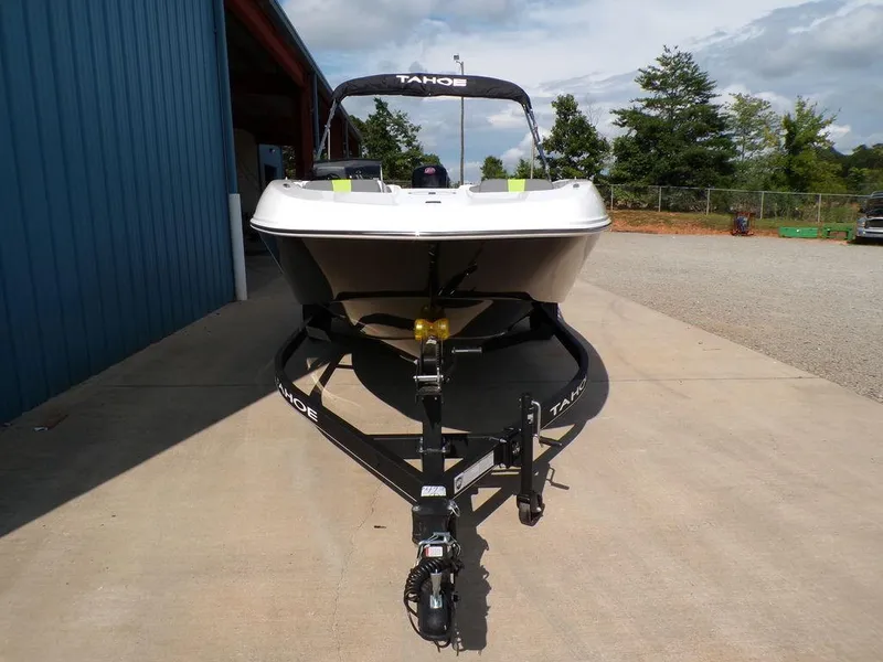 Slide: The Image of 2024 Tahoe T18 boat on trailer, parked outdoors near a blue building. - 21