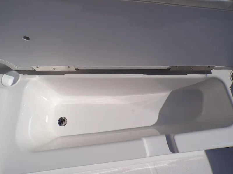 Slide: The Image of 2024 Tahoe T18 boat storage compartment, open lid, white interior. - 22