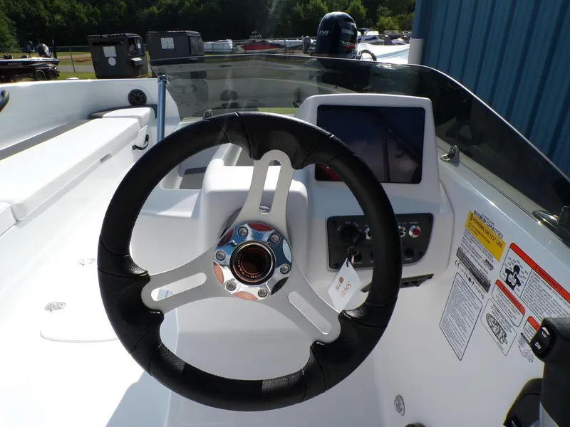 Slide: The Image of 2024 Tahoe T18 boat steering wheel and dashboard controls. - 7