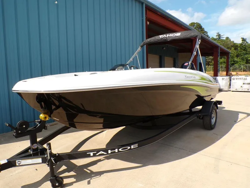 Slide: The Image of 2024 Tahoe T18 boat on trailer, parked outside a blue building. - 9