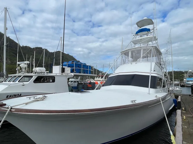 Slide: The Image of 1997 Buddy Davis Sportfisher Convertible docked at marina under cloudy sky. - 2