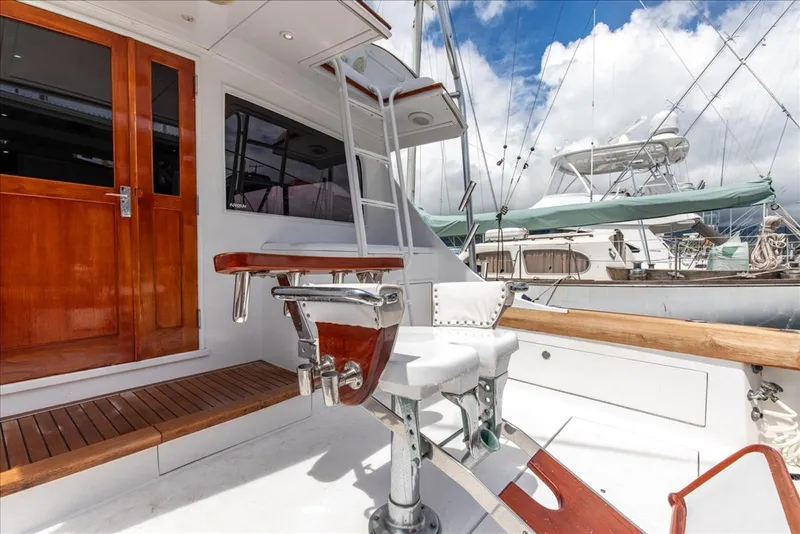 Slide: The Image of 1997 Buddy Davis Sportfisher Convertible boat deck with fishing chair and wooden accents. - 21